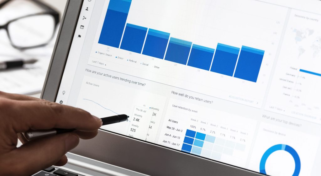 Businessman using Google Analytics in the office on the touch screen of his laptop. for continued keyword research